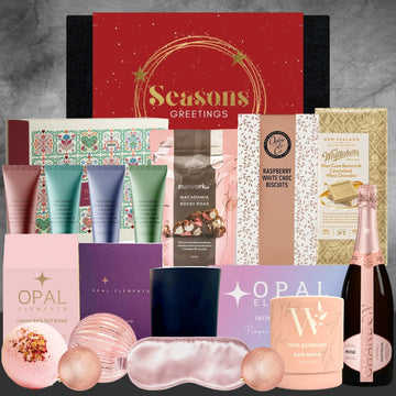 Luxury gift hamper with bath bombs, hand balms, chocolates, candle, eye mask, rose geranium bath bomb, and Chandon rosé bottle