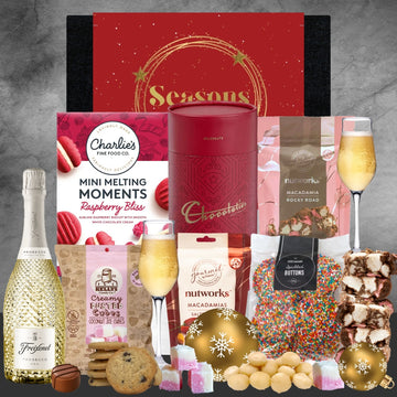 Holiday gift hamper with Prosecco, chocolates, cookies, macadamia nuts, raspberry biscuits, and festive decorations