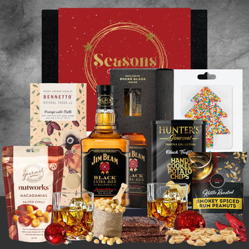 Holiday gift box with Jim Beam bourbon, macadamia nuts, dark chocolate, spiced peanuts, truffle chips, and festive treats