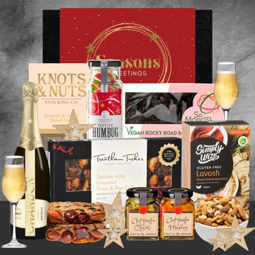 Holiday gift hamper with Chandon sparkling wine, Italian fruit cake, nuts, vegan treats, and festive decorations