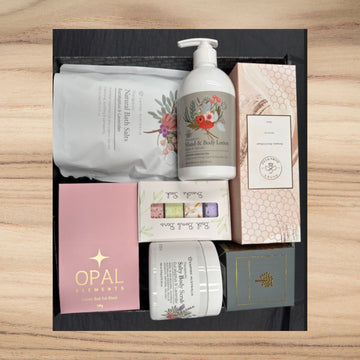Luxury self-care gift box with natural bath salts, hand & body lotion, bath bombs, salty body scrub, scented candle, and rose spray