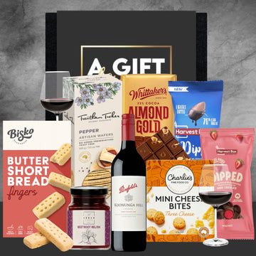 Assorted gourmet food and wine gift set with branded products on a gray background