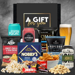 Assorted snacks and drinks with a 'Gift for You' box on a gray background