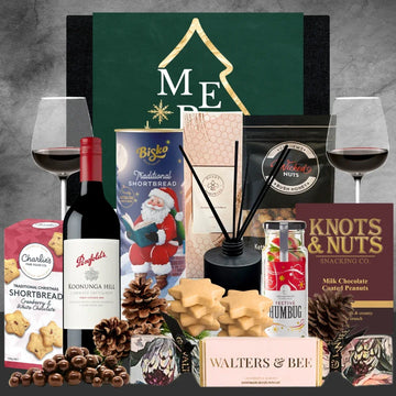 Collection of Christmas festive items including wine, cookies, and decorative items on a gray background.
