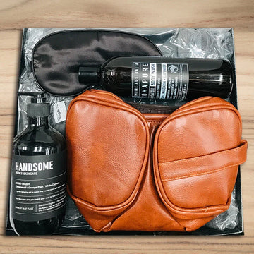 Set of leather pouches with bottles labeled 'Handsome' and 'Napalm' on a wooden surface.