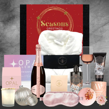 Christmas Gift set with bath towel, champagne, candles, and other items on a gray background