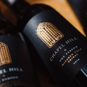 Close-up of Chapel Hill wine bottle labels on a wooden surface