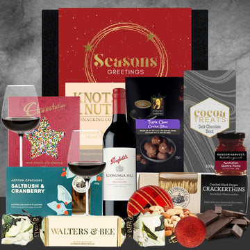 Christmas Assorted holiday gift items including wine, chocolates, and treats on a gray background.