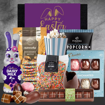 Assorted Easter treats including a Cadbury Dairy Milk chocolate bunny, popcorn, and chocolate eggs on a gray background.