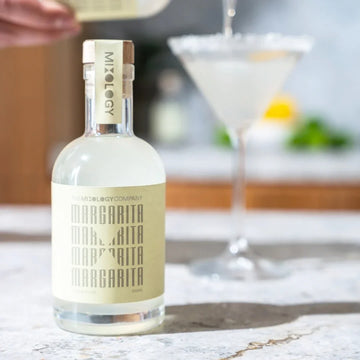 Bottle of Mitology Margarita on a marble surface with a blurred background