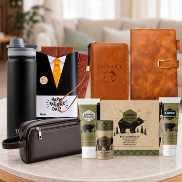 Travel Essentials Gift Hamper for Dad by Tastebuds featuring a travel bottle, passport holder, leather notebook, grooming kit and Father's Day chocolates.