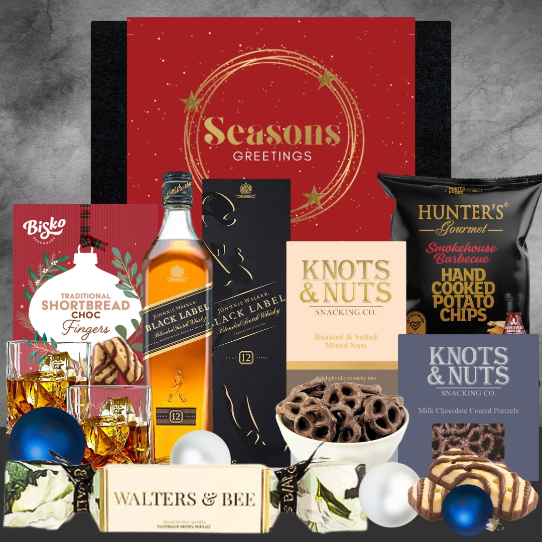 Holiday gift box with Johnnie Walker Black Label whisky, shortbread fingers, potato chips, nuts, chocolate pretzels, and festive decorations