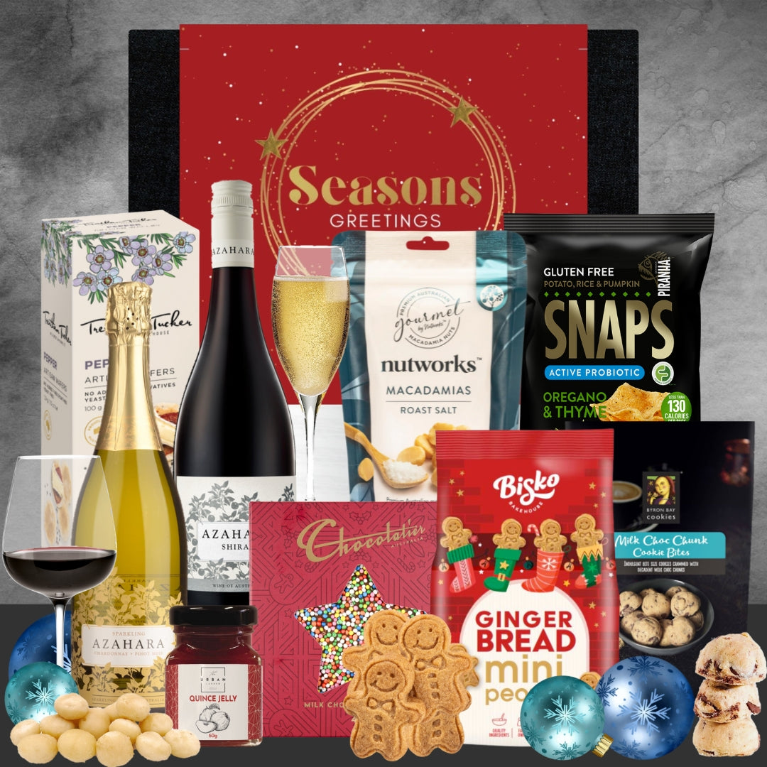 Holiday gift hamper with wine, gingerbread cookies, macadamia nuts, crackers, and festive decorations