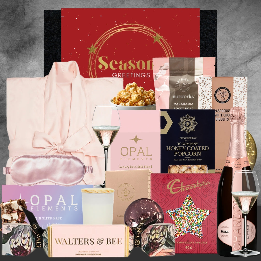 Christmas Gourmet gift basket with wine, popcorn, and other treats on a gray background