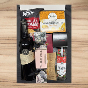 Gift box with Pepperjack Shiraz wine, Kettle chips, Charlie's mini cheese bites, Walters & Bee nougat, festive humbug candy, and Christmas pudding