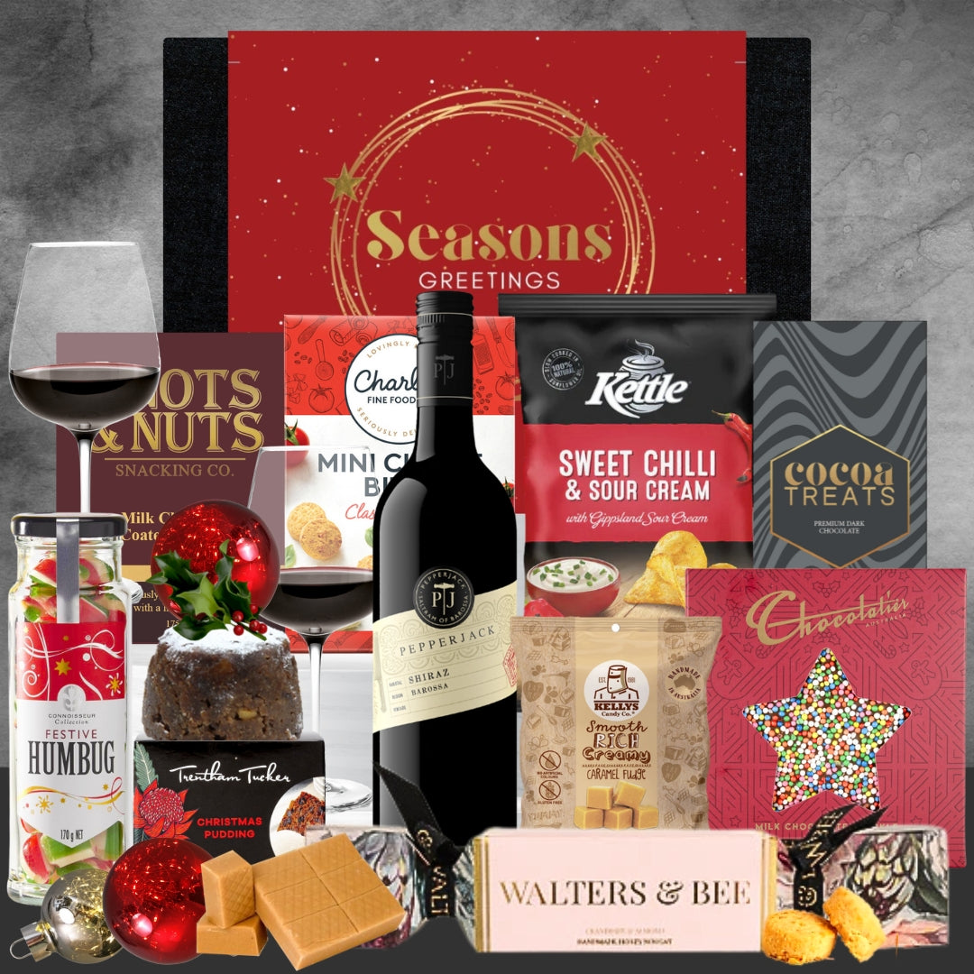 Holiday gift hamper with Shiraz wine, snacks, chocolates, Christmas pudding, and festive decorations