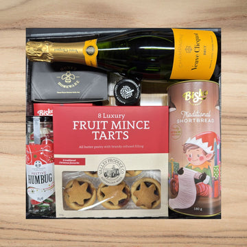 Luxury gift box with Veuve Clicquot champagne, fruit mince tarts, traditional shortbread, festive humbug sweets, and cheese knife set