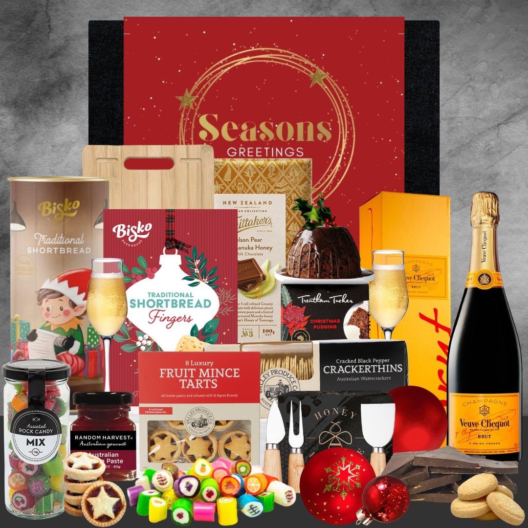 Christmas gift hamper with champagne, shortbread, fruit mince tarts, Christmas pudding, chocolates, candy, and festive decorations