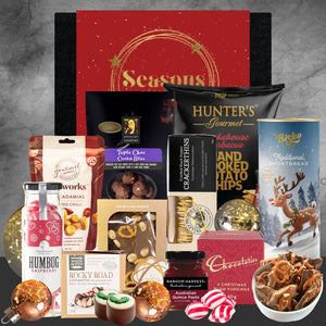 Holiday gourmet gift box with flavored nuts, cookies, crackers, potato chips, shortbread, chocolates, plum puddings, quince paste, and festive decor