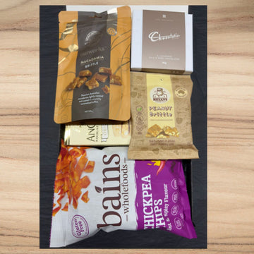 Assorted snack pack with Nutworks macadamia brittle, Kelly's peanut brittle, Pure Indulgence chocolates, Anco nougat, and Bains wholefoods chickpea chips