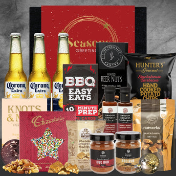 Gift hamper with Corona beer, BBQ sauce, rubs, beer nuts, potato chips, chocolates, and snacks with a Seasons Greetings card