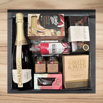 Chandon sparkling wine with gluten-free lavosh, Italian fruit & nut cake, raspberry humbug candy, olives, vegan rocky road bar, and mixed nuts gift box