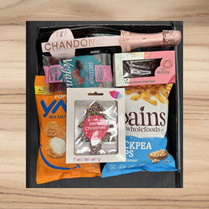 Gift box with Chandon rosé sparkling wine, vegan candy, vegan rocky road bar, sea salt popcorn, chickpea chips, and Christmas tree chocolate