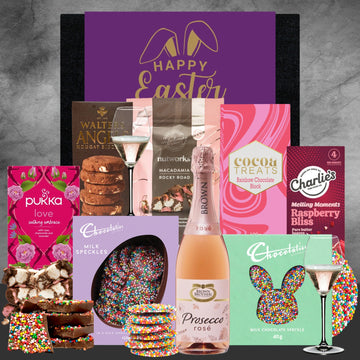 Assorted Easter-themed products including chocolate, cookies, and a bottle of prosecco on a gray background.
