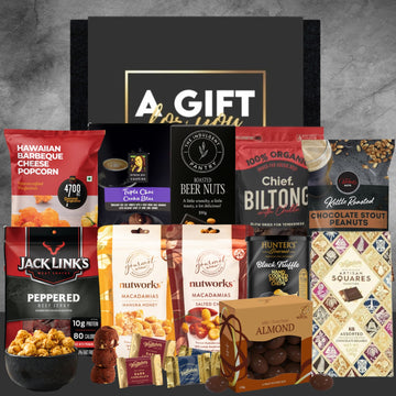 Assorted gourmet snacks in a gift box with visible brand names on packaging.