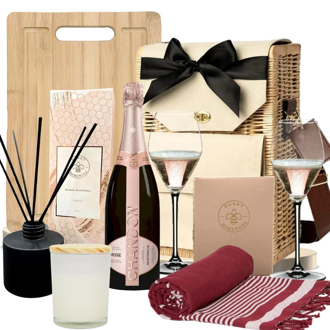 Gourmet gift basket with champagne, glasses, and other items on a white background