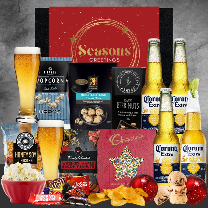 Gourmet gift set with Corona Extra beer, popcorn, and snacks on a gray background