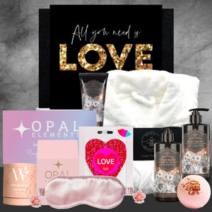 Collection of beauty products and a 'All you need is LOVE' sign on a gray background