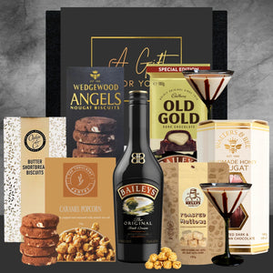 Collection of snacks and drinks including Baileys, Old Gold, and Wedgewood Angels on a gray background.