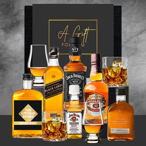 Collection of whiskey bottles and glasses with a 'Gift for You' card on a gray background