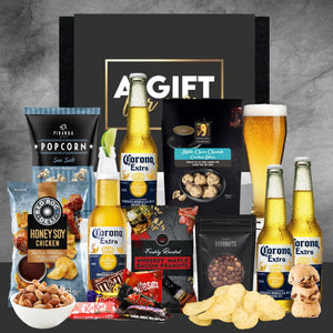 Gift set with Corona beer, snacks, and candies on a gray background