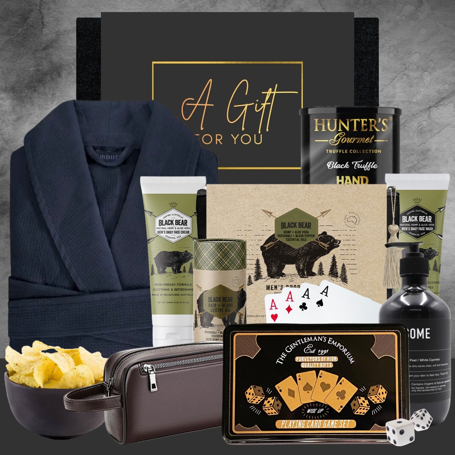 Collection of luxury items including a robe, snacks, and branded products on a textured surface.