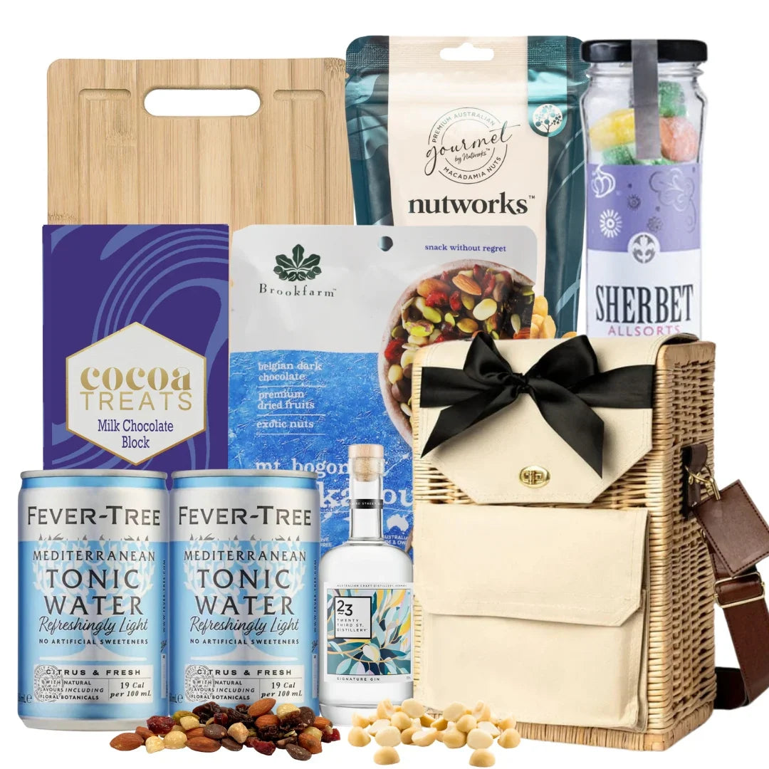 Gift basket with assorted items including tonic water, chocolate, and nuts on a white background