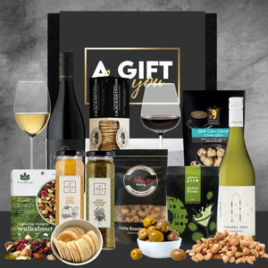 Gift set with wine, snacks, and other items on a gray background
