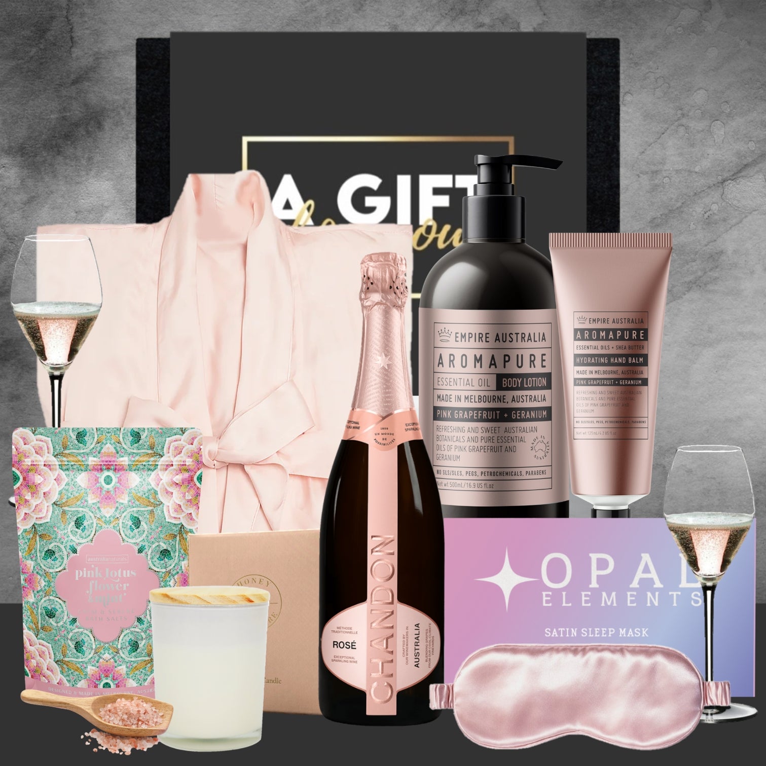 Gifting set with champagne, bath products, and a robe on a gray background