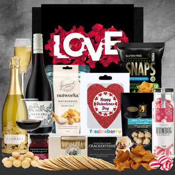 Gourmet gift basket with Valentine's Day-themed items on a gray background