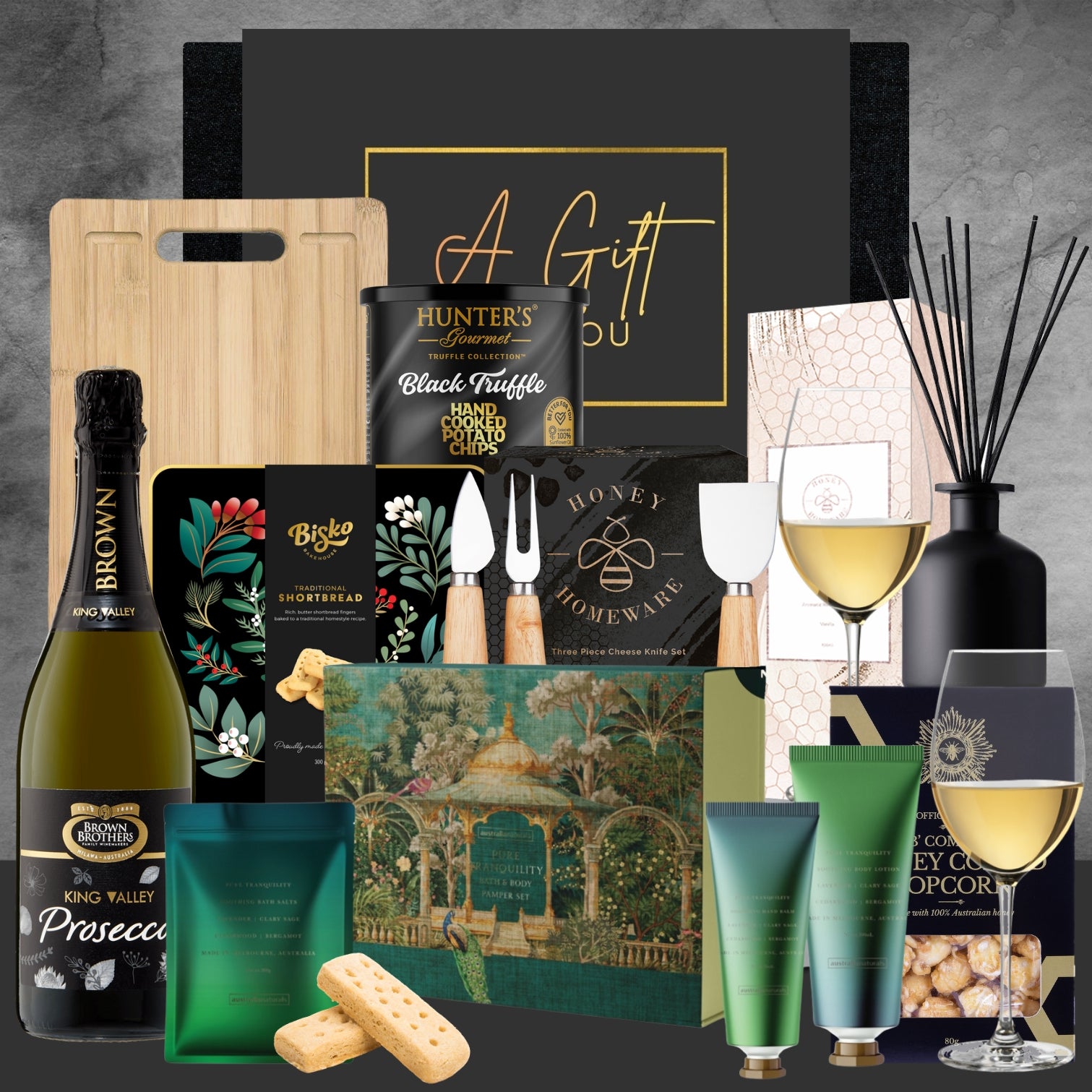 Gourmet gift basket with wine, truffles, and other items on a dark background