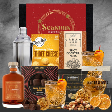 Gourmet gift set with drinks and snacks on a gray background