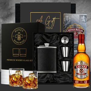 Gourmet gift set with Chivas Regal whiskey, glasses, and flask on a gray background