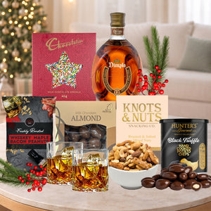 Gourmet gift set with alcohol, snacks, and chocolates on a table.