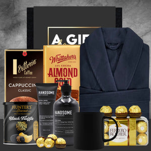Gourmet gift set with coffee, chocolate, and bathrobe on a gray background
