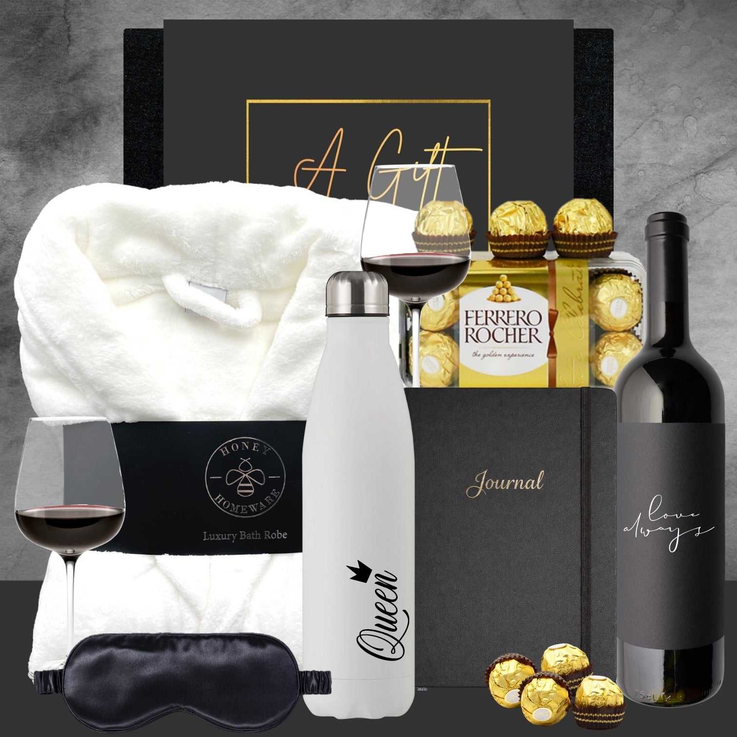 Gourmet gift set with wine, chocolates, and other items on a gray background