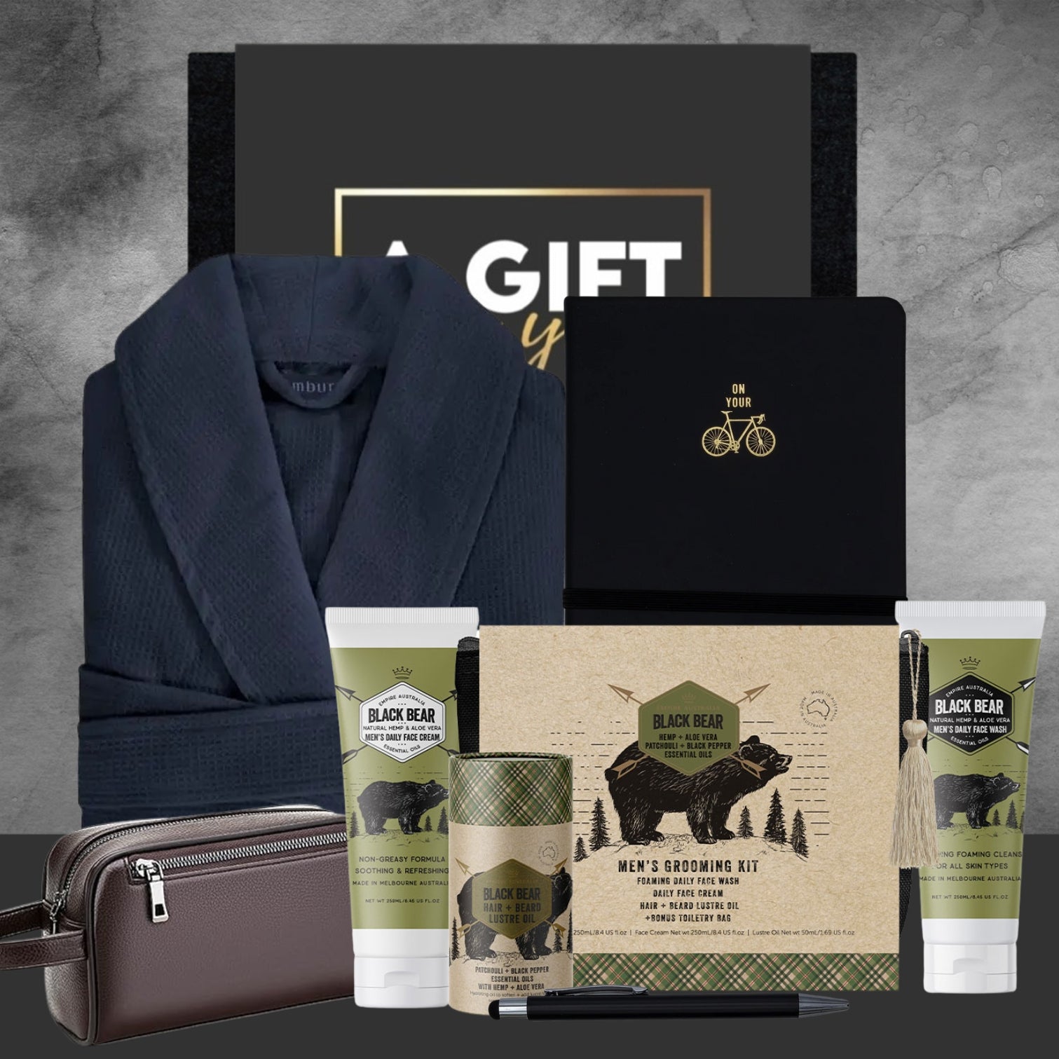 Men's grooming kit with robe, toiletries, and stationery on a gray background
