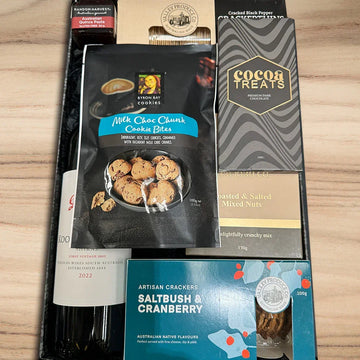 Assorted food products including cookies, chocolate treats, and crackers on a wooden surface.