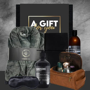 Gift set with robe, sleep mask, and toiletries on a gray background