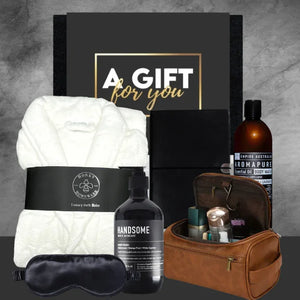 Gift set with white blanket, bottles, and toiletries on a gray background